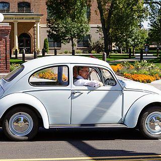 John 麦克维恩 driving a light blue beetle